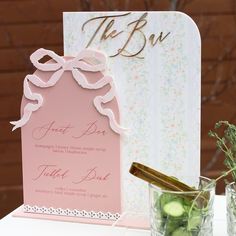 a table topped with two vases filled with cucumbers and an empty card