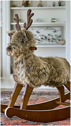 a stuffed reindeer sitting on top of a wooden rocking horse