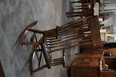 a wooden rocking chair sitting on top of a carpeted floor