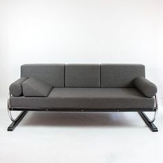 a gray couch sitting on top of a metal frame