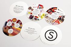 four circular coasters with different designs on the front and back sides, all printed in black and white