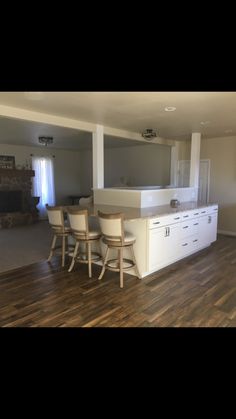 an empty kitchen and dining room with wood floors