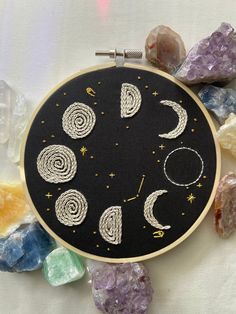 an embroidery project with the phases of the moon and stars on it, surrounded by crystals