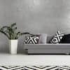 a white table with black and white pillows on it next to a potted plant