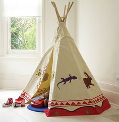 two teepees with animals on them in front of a window