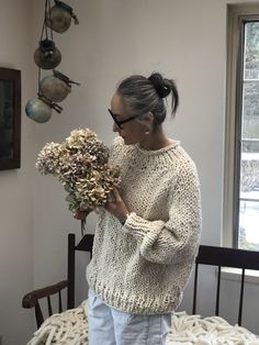 a woman is holding flowers in her hands