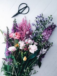 a bunch of flowers sitting next to a pair of scissors