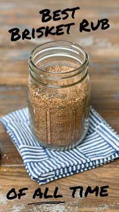 a glass jar filled with spices sitting on top of a blue and white towel next to a