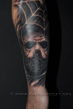 a man with a skull and spider web tattoo on his leg is wearing a black mask