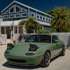 a green sports car parked in front of a house