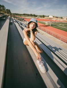 a woman sitting on the side of a bleachers