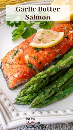 grilled salmon and asparagus on a white plate with lemon wedges in the background