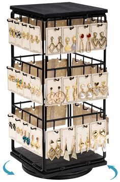 a black and white display case with lots of jewelry on it's sides, including earrings