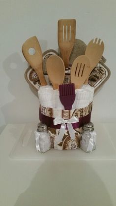 wooden utensils and spoons are in a basket with some fabric on it