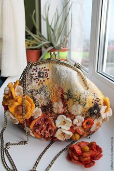 a purse with flowers on it sitting next to a window