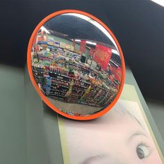 a mirror that is sitting on top of a table next to a book and magazine