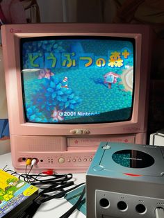 an old tv sitting on top of a table next to a nintendo wii game controller