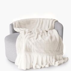 a white blanket sitting on top of a gray chair