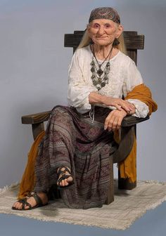 an old woman sitting in a chair with her hands on her knees and wearing sandals