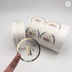 a hand holding a magnifying glass with the letter t on it and four round stickers