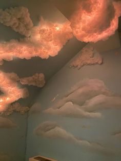 clouds painted on the wall and ceiling in a child's room with lights coming from them