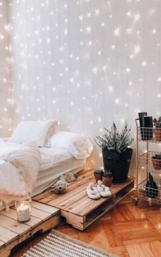 a bedroom with wooden pallets and string lights on the wall, along with an unmade bed