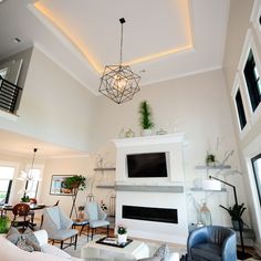 a living room filled with furniture and a flat screen tv mounted on the wall above a fireplace