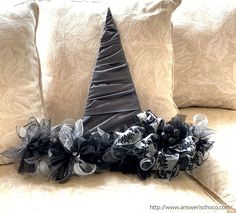 a black and white witch hat on top of a couch with the words witch hat warth written above it