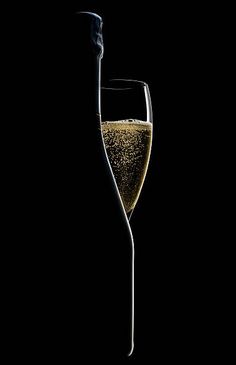 a wine glass filled with champagne on a black background