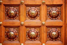 the wooden door with metal knobs and decorative designs on it's sides is shown