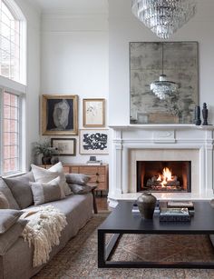 a living room filled with furniture and a fire place in the middle of it's wall