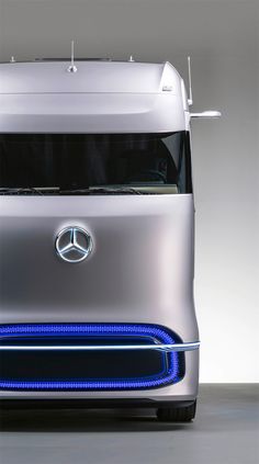 the front end of a silver mercedes semi - truck with blue lights on it's grille