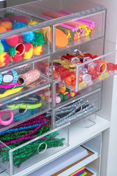 the drawers are filled with plastic toys and other crafting supplies for kids to use