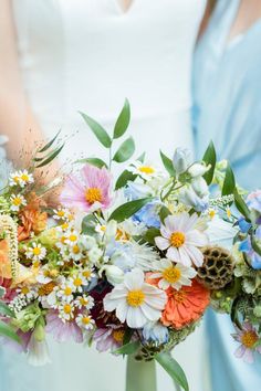 two bridesmaids holding bouquets of flowers in their hands