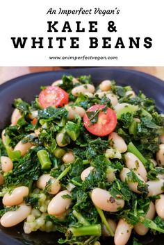 kale and white beans with tomatoes in a black bowl