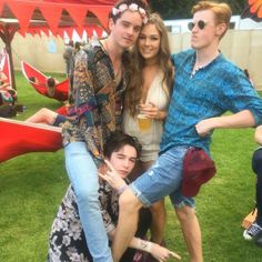 four people posing for a photo in the grass