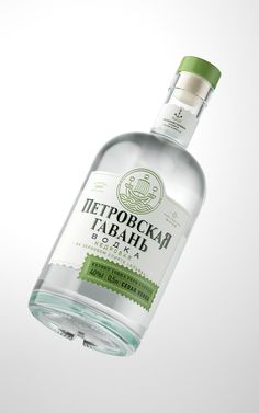 a bottle of alcohol with a green cap on the top is flying in the air