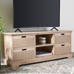 an entertainment center with wicker drawers and a flat screen tv