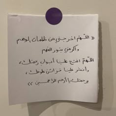 a piece of paper that has been written in two different languages on it, with an oval purple dot at the top