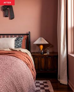 a bed room with a neatly made bed next to a window and a lamp on a table