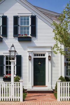 a white house with black shutters and green door