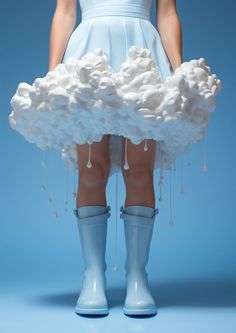 a woman in blue dress and rain boots with clouds on her legs, standing against a blue background