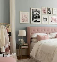 a bedroom with blue walls and pictures on the wall above the bed, along with a pink tufted headboard