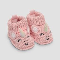 a pair of pink crocheted slippers with unicorns on the front and side