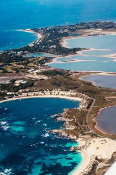 an aerial view of the ocean and coastline from above, looking down on some small islands