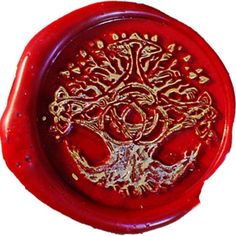 a red wax seal with a tree on it's side and gold foiling