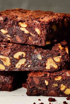 several brownies stacked on top of each other with nuts in the middle and chocolate chips all over them