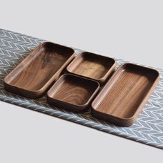 three wooden trays sitting on top of a table