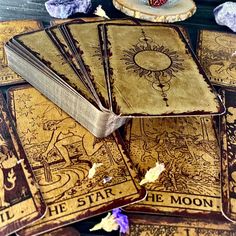 several old books sitting on top of each other in front of some rocks and flowers