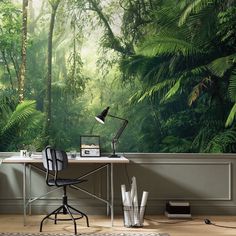 a desk with a lamp on it in front of a forest wall mural